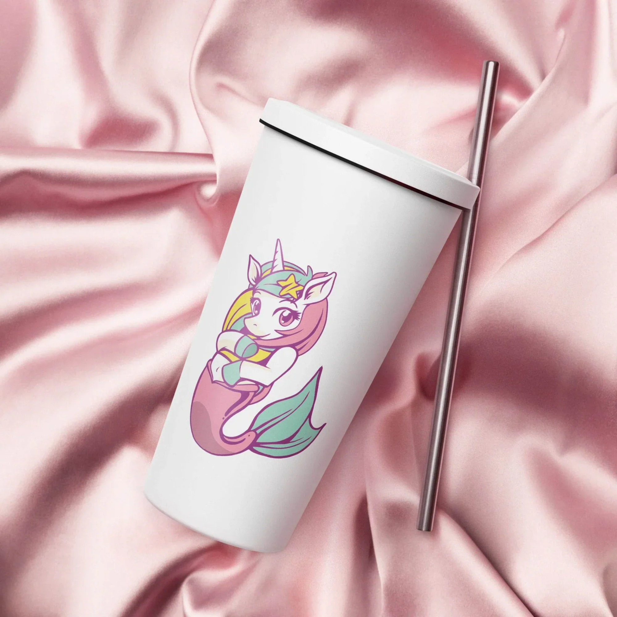 White tumbler with a unicorn mermaid design on a pink satin background